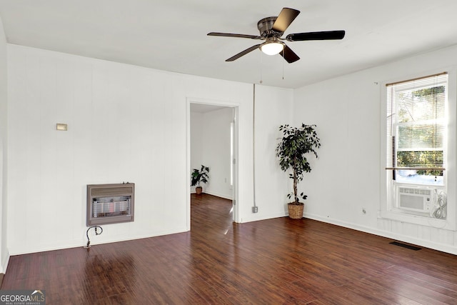 empty room with cooling unit, dark hardwood / wood-style floors, ceiling fan, and heating unit