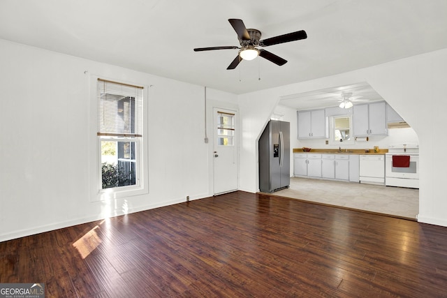 unfurnished living room with ceiling fan, hardwood / wood-style floors, and sink