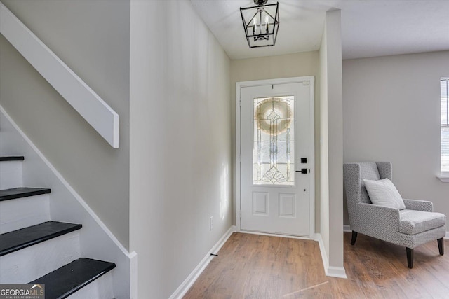 entrance foyer featuring hardwood / wood-style floors and an inviting chandelier