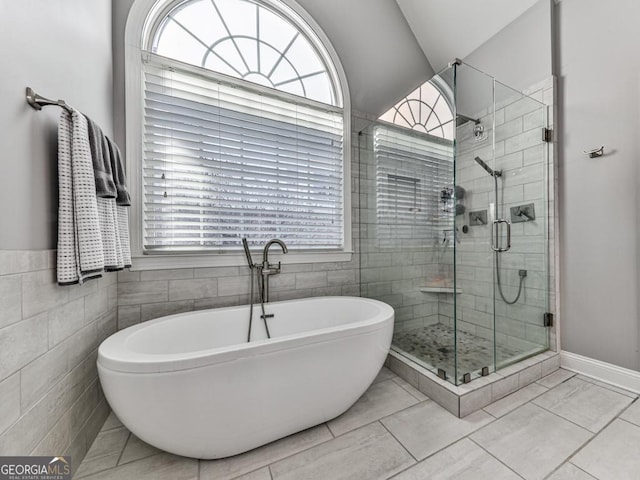 bathroom with plus walk in shower, lofted ceiling, and tile walls