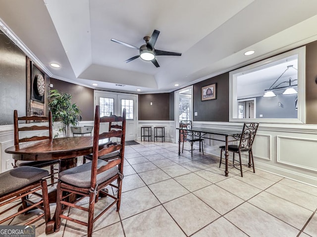 tiled dining space with crown molding, a tray ceiling, ceiling fan, and french doors