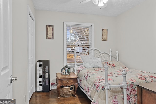 bedroom with a textured ceiling, ceiling fan, a closet, and dark hardwood / wood-style floors