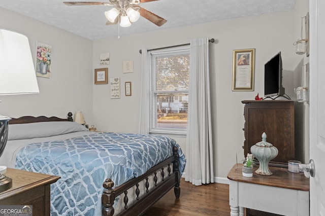 bedroom with ceiling fan, dark wood-type flooring, and a textured ceiling