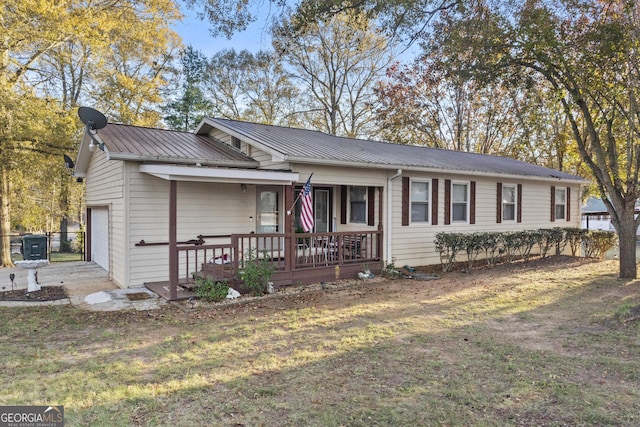 single story home featuring covered porch, a garage, and a front lawn