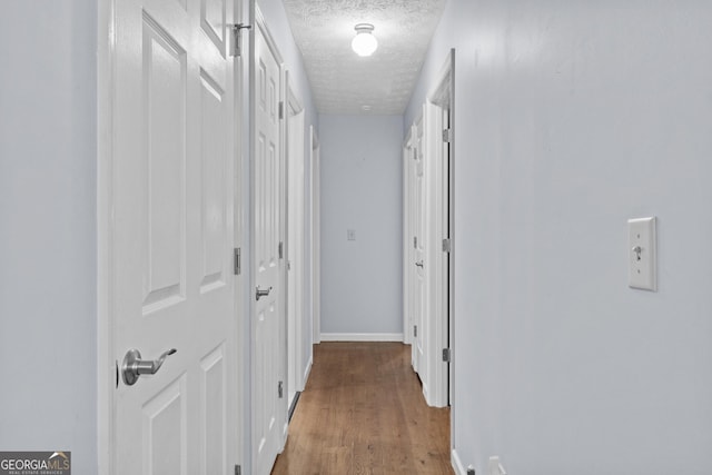 corridor featuring hardwood / wood-style floors and a textured ceiling