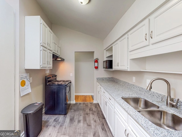 kitchen with lofted ceiling, white cabinetry, black appliances, and sink