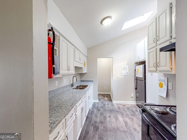 kitchen with white cabinetry, sink, black range with electric cooktop, and lofted ceiling with skylight