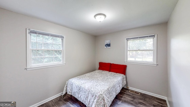 bedroom with dark wood-type flooring