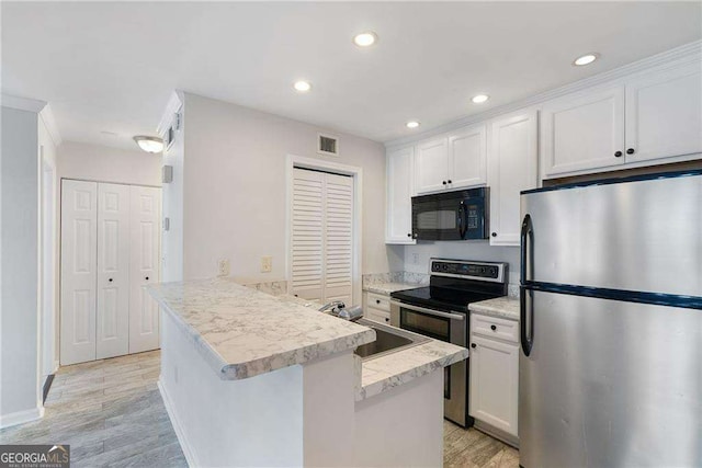 kitchen with visible vents, white cabinets, appliances with stainless steel finishes, light countertops, and a sink