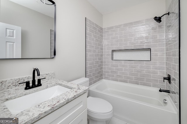 full bathroom featuring vanity, tiled shower / bath combo, and toilet