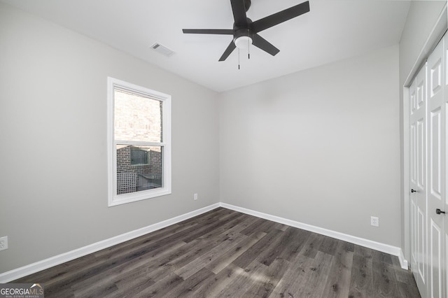 unfurnished bedroom featuring a closet, ceiling fan, and dark wood-type flooring