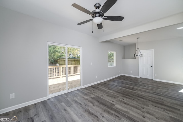 unfurnished living room with ceiling fan with notable chandelier and dark hardwood / wood-style flooring