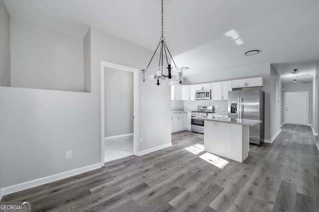 kitchen featuring a center island, stainless steel appliances, wood-type flooring, decorative light fixtures, and white cabinets