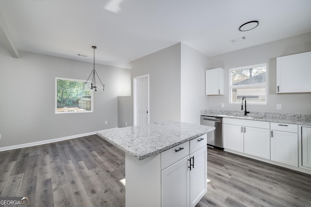 kitchen with stainless steel dishwasher, pendant lighting, white cabinets, and light hardwood / wood-style floors