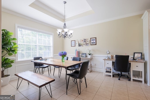 dining space featuring a raised ceiling, light tile patterned floors, an inviting chandelier, and crown molding