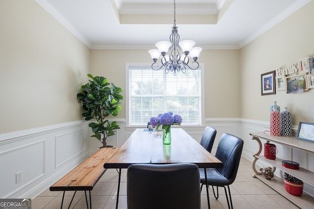 dining space featuring light tile patterned flooring, a tray ceiling, crown molding, and a notable chandelier