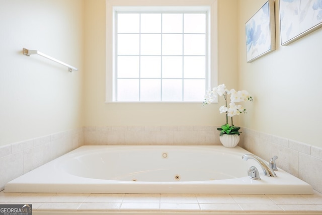 bathroom with tiled tub and a healthy amount of sunlight