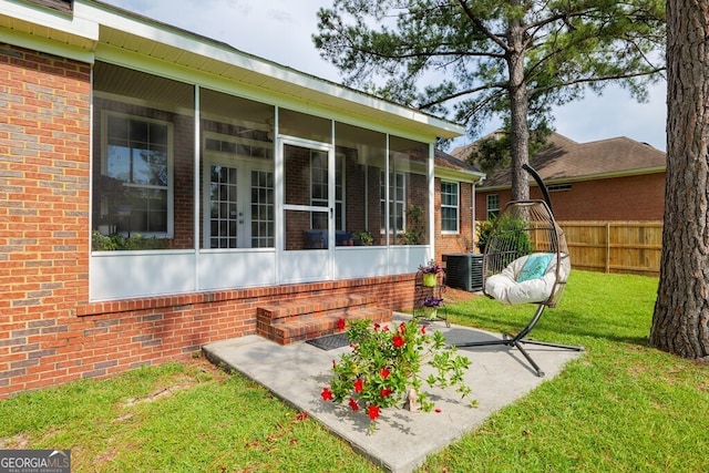 exterior space with central AC, a yard, a patio, and a sunroom