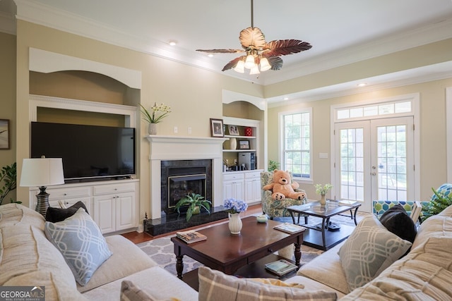 3798 Bermuda Run Dr, Valdosta, GA 31605 - living area featuring ornamental molding, wood finished floors, french doors, built in shelves, and a fireplace