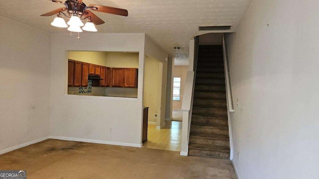 interior space with ceiling fan, carpet flooring, and a textured ceiling