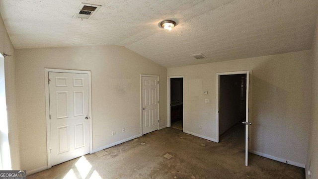 unfurnished bedroom featuring vaulted ceiling and a textured ceiling