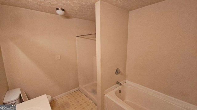 bathroom with plus walk in shower, a textured ceiling, and toilet