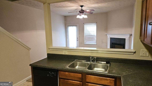 kitchen featuring ceiling fan, black dishwasher, sink, and a textured ceiling