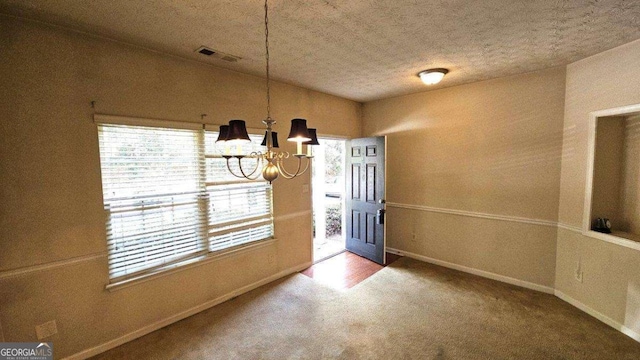 unfurnished dining area featuring carpet flooring, a notable chandelier, and a textured ceiling