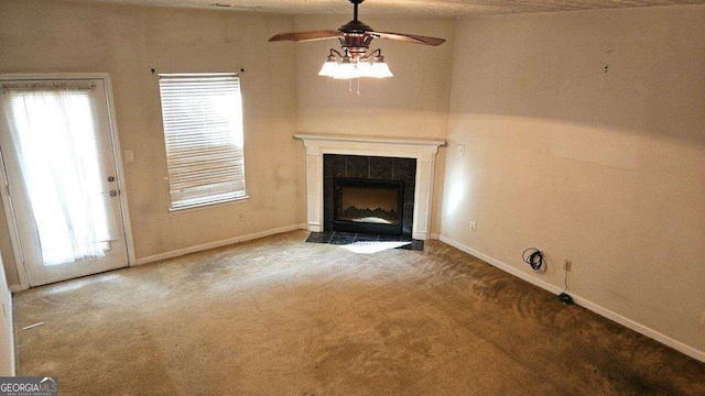 unfurnished living room featuring a tiled fireplace, plenty of natural light, and carpet floors