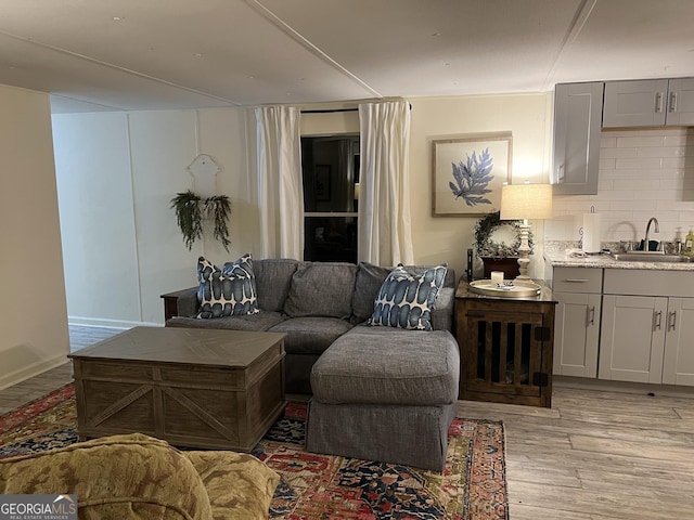 living room with light hardwood / wood-style floors and sink