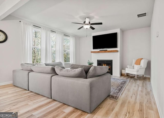 living room with visible vents, a ceiling fan, and wood finished floors