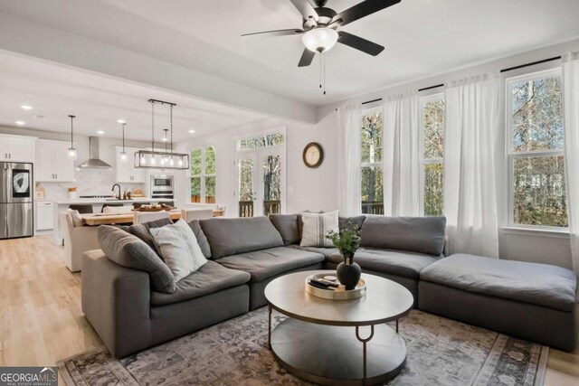 living room featuring light hardwood / wood-style flooring, plenty of natural light, and ceiling fan