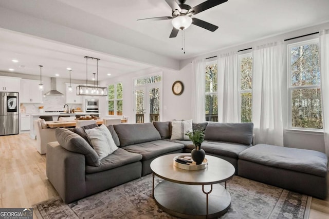 living room with recessed lighting, light wood-style floors, and ceiling fan