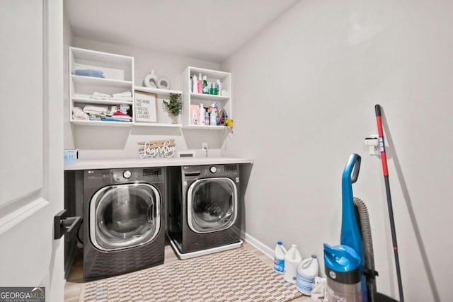 washroom featuring baseboards, laundry area, and washer and clothes dryer