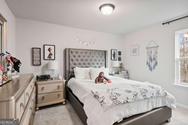 bedroom featuring baseboards and light carpet