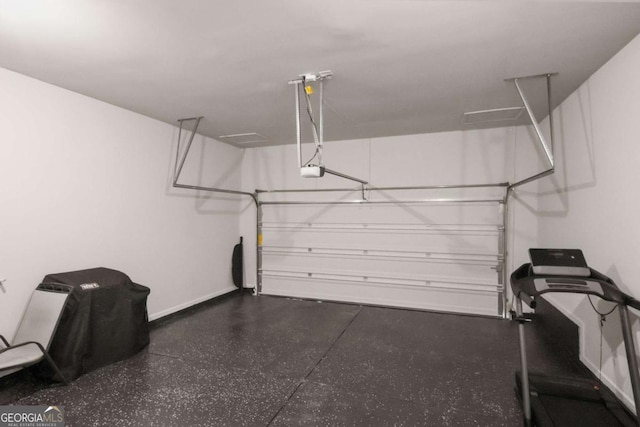 garage featuring a garage door opener and baseboards