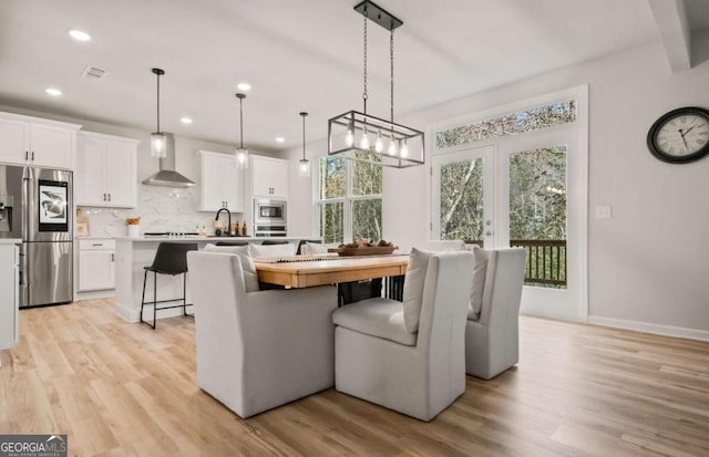 dining room with light wood-style flooring, recessed lighting, and a healthy amount of sunlight