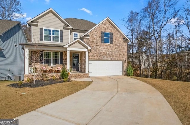craftsman-style house featuring an attached garage, brick siding, a front lawn, driveway, and covered porch