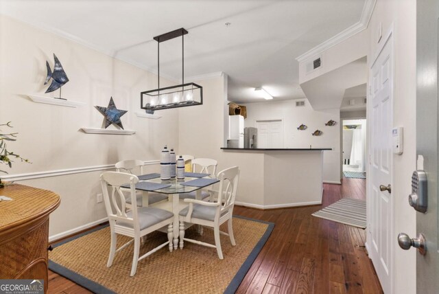 dining area with dark hardwood / wood-style flooring and ornamental molding