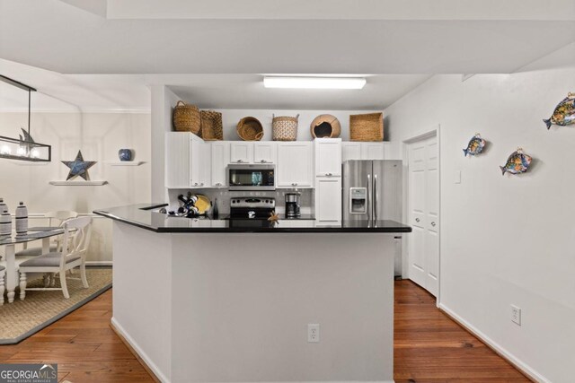 kitchen featuring dark hardwood / wood-style flooring, a chandelier, decorative light fixtures, white cabinets, and appliances with stainless steel finishes