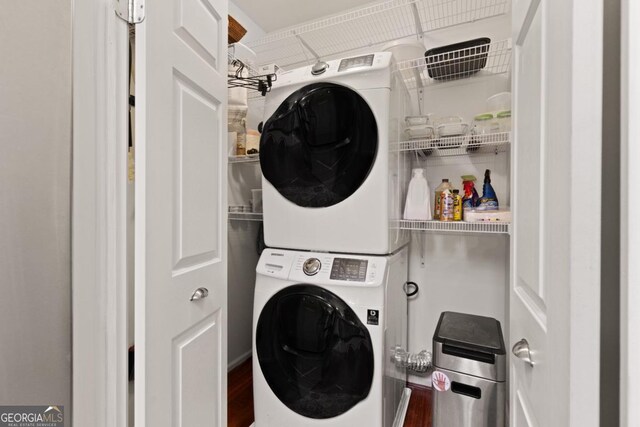 laundry room with hardwood / wood-style floors and stacked washer and clothes dryer