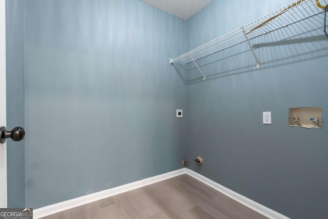 clothes washing area with hookup for an electric dryer, hookup for a washing machine, hardwood / wood-style flooring, and hookup for a gas dryer