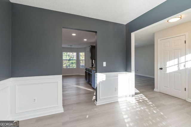 interior space with light hardwood / wood-style floors and a textured ceiling