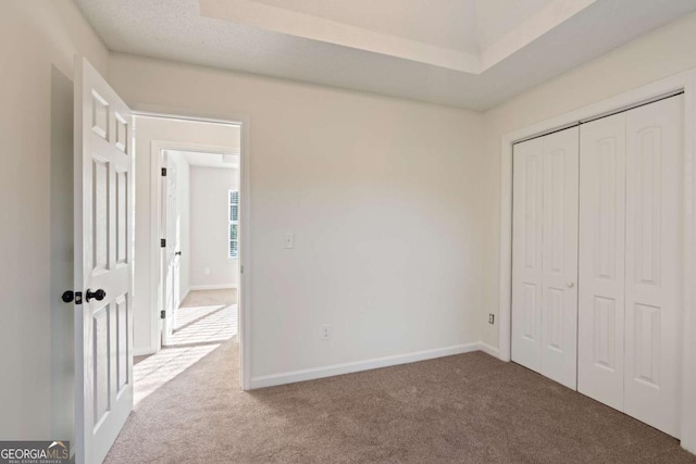 unfurnished bedroom featuring carpet, a textured ceiling, and a closet