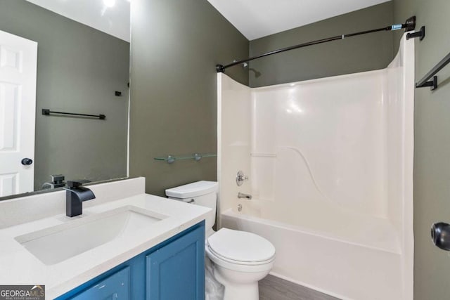 full bathroom with washtub / shower combination, hardwood / wood-style floors, vanity, and toilet