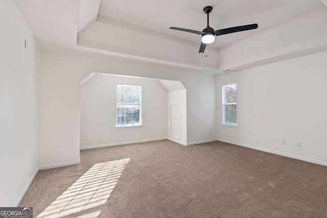 additional living space with ceiling fan and light carpet