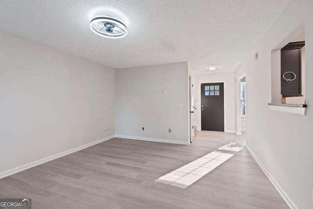 foyer featuring a textured ceiling and light hardwood / wood-style flooring