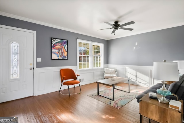 sitting room with hardwood / wood-style flooring, ceiling fan, and ornamental molding