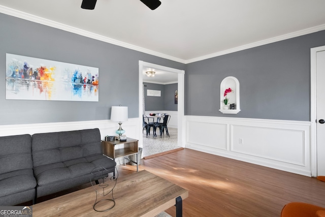 living room featuring hardwood / wood-style flooring, ceiling fan, and crown molding