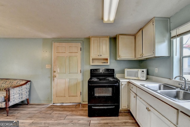 3615 Miller Bottom Rd, Loganville, GA 30052 - kitchen featuring black electric range, cream cabinetry, light hardwood / wood-style flooring, and sink